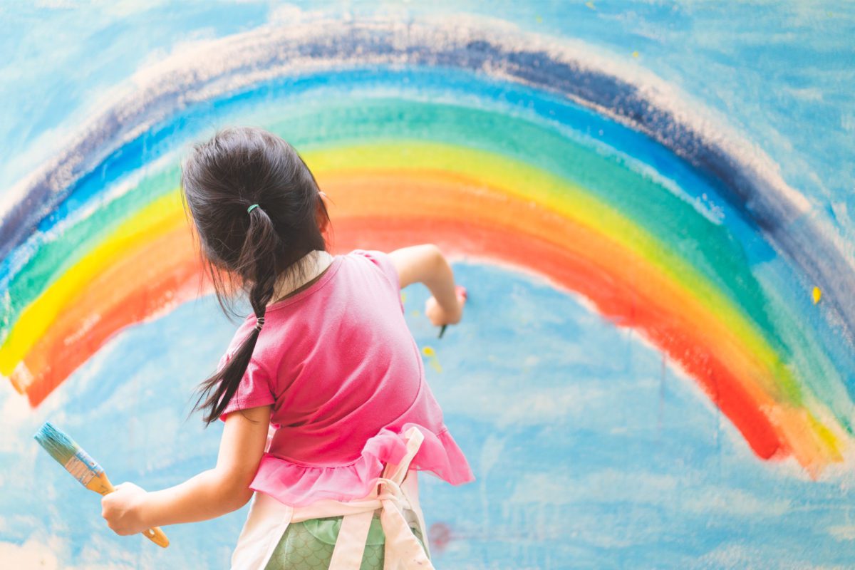 Asian,little,girl,is,painting,the,colorful,rainbow,and,sky